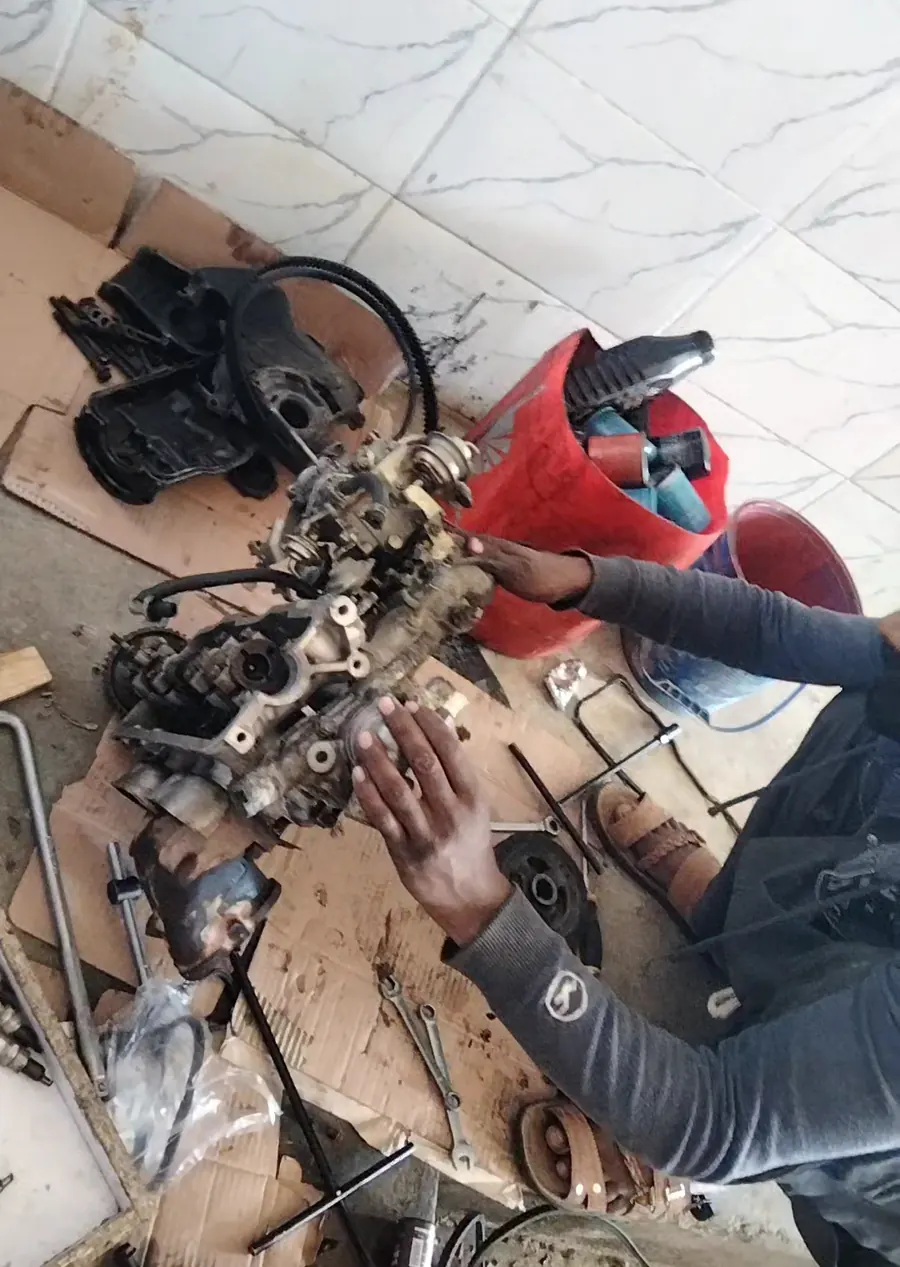 Hands working on engine parts on the bench
