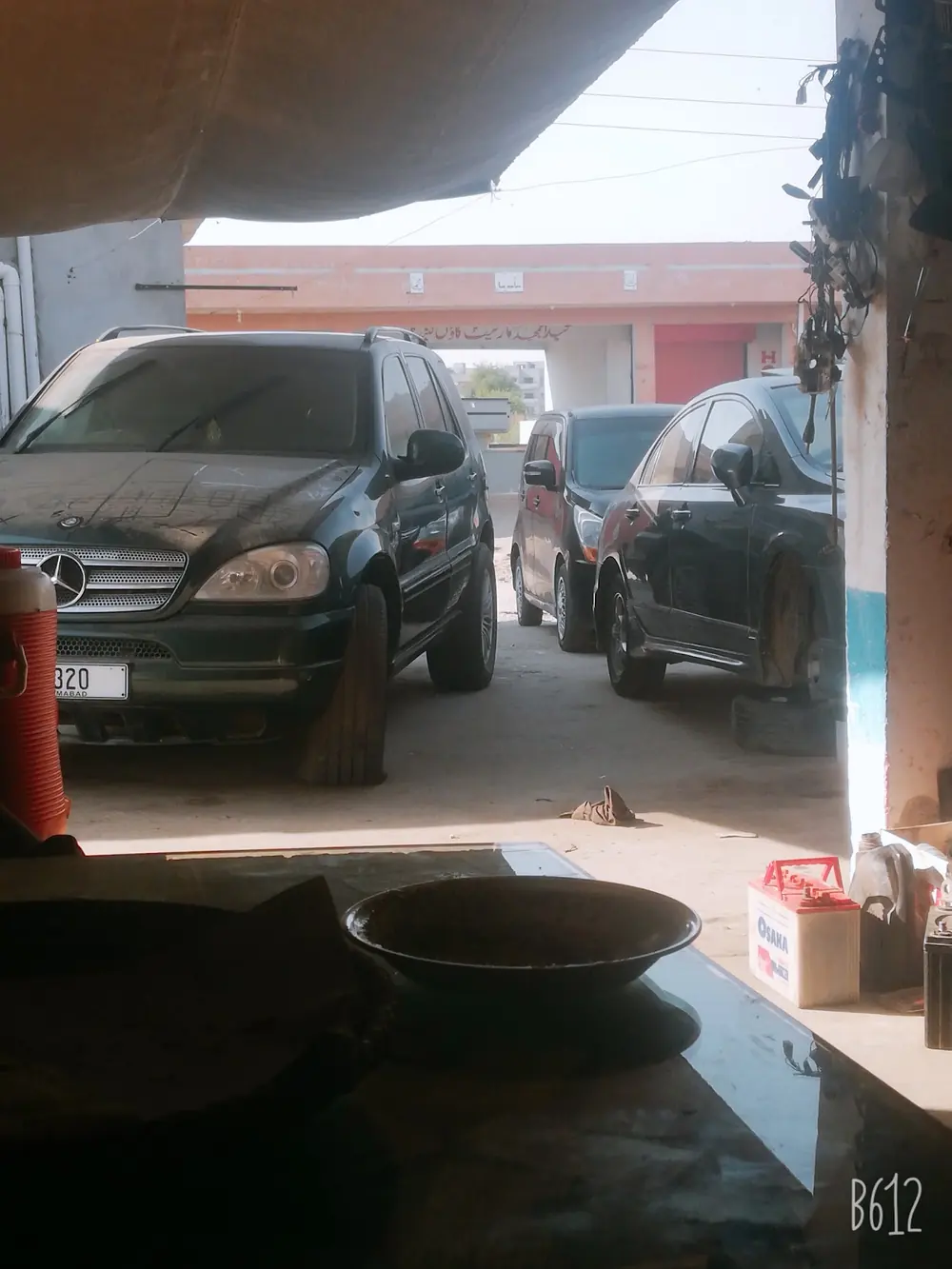 View from inside the workshop out to cars parked in front